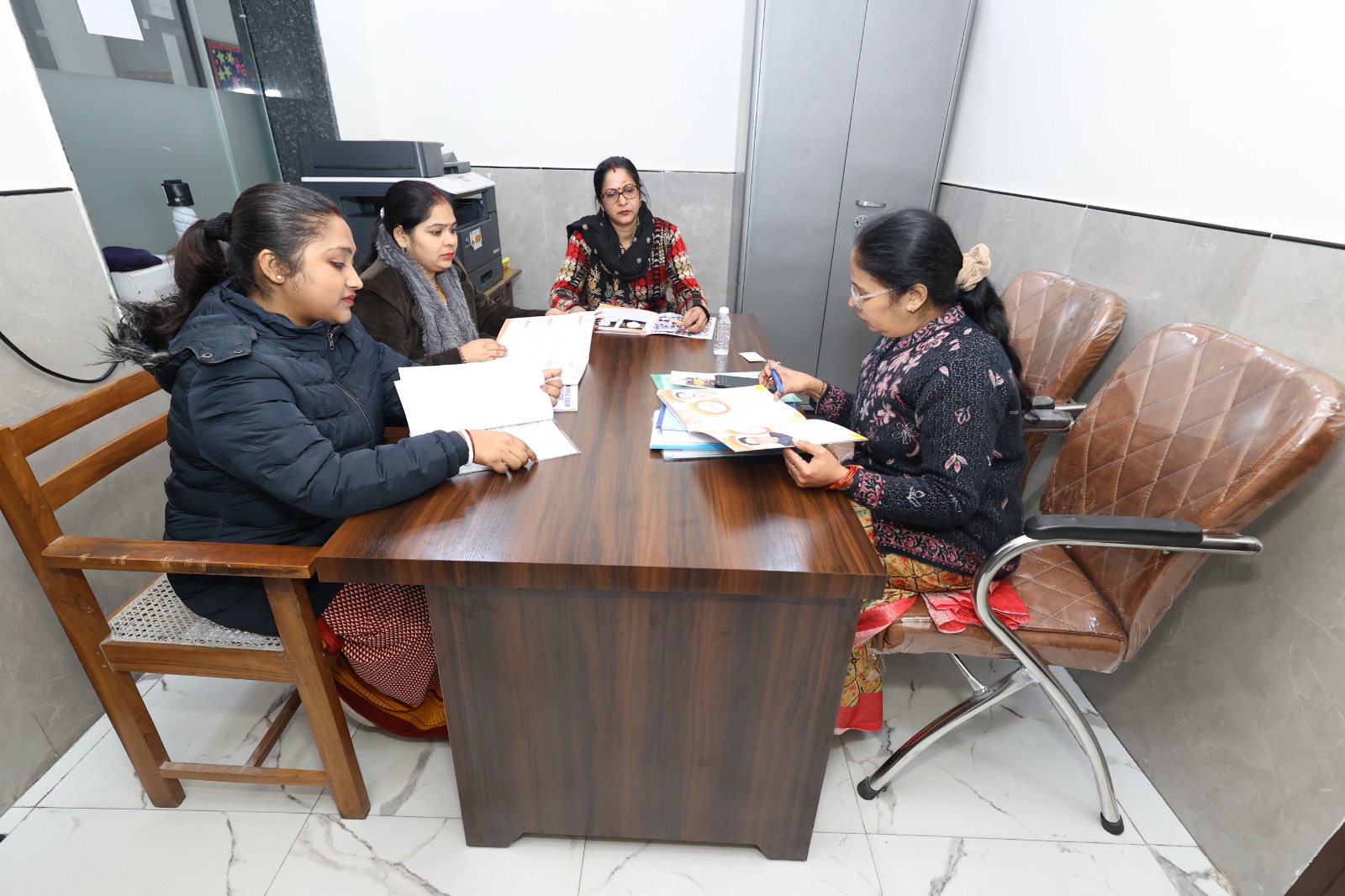 Staff at the admissions desk reviewing files with a parent