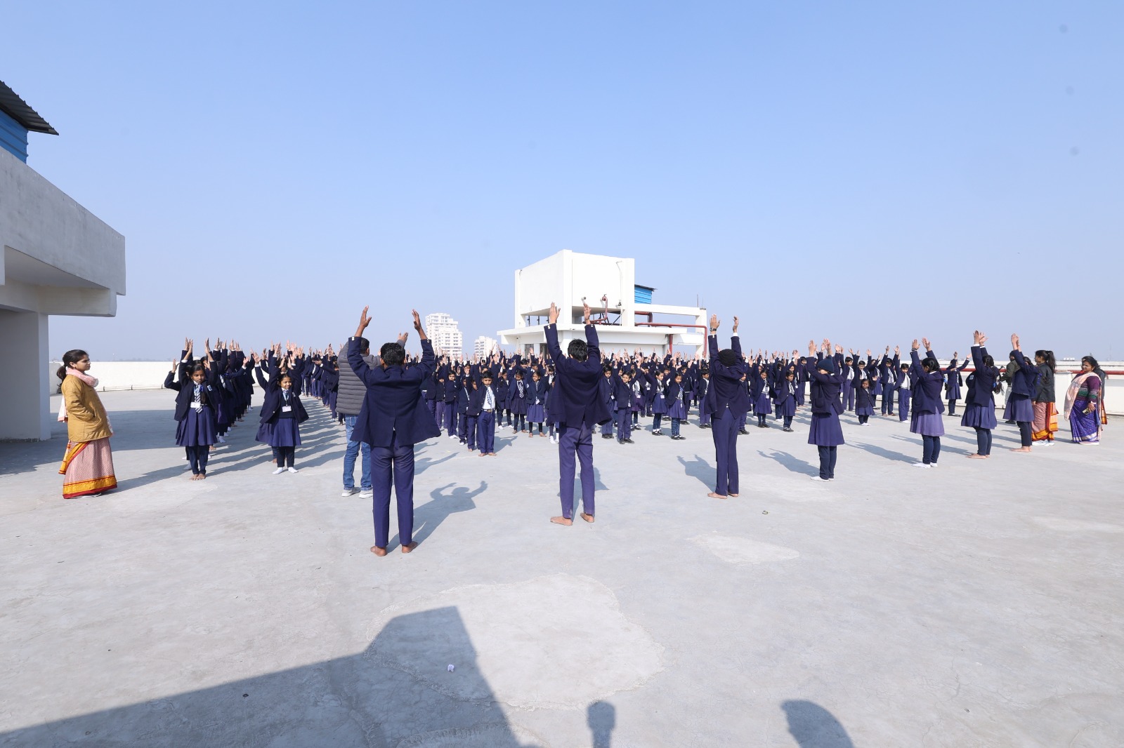 Students arranged in a wide circle on the rooftop for morning drill