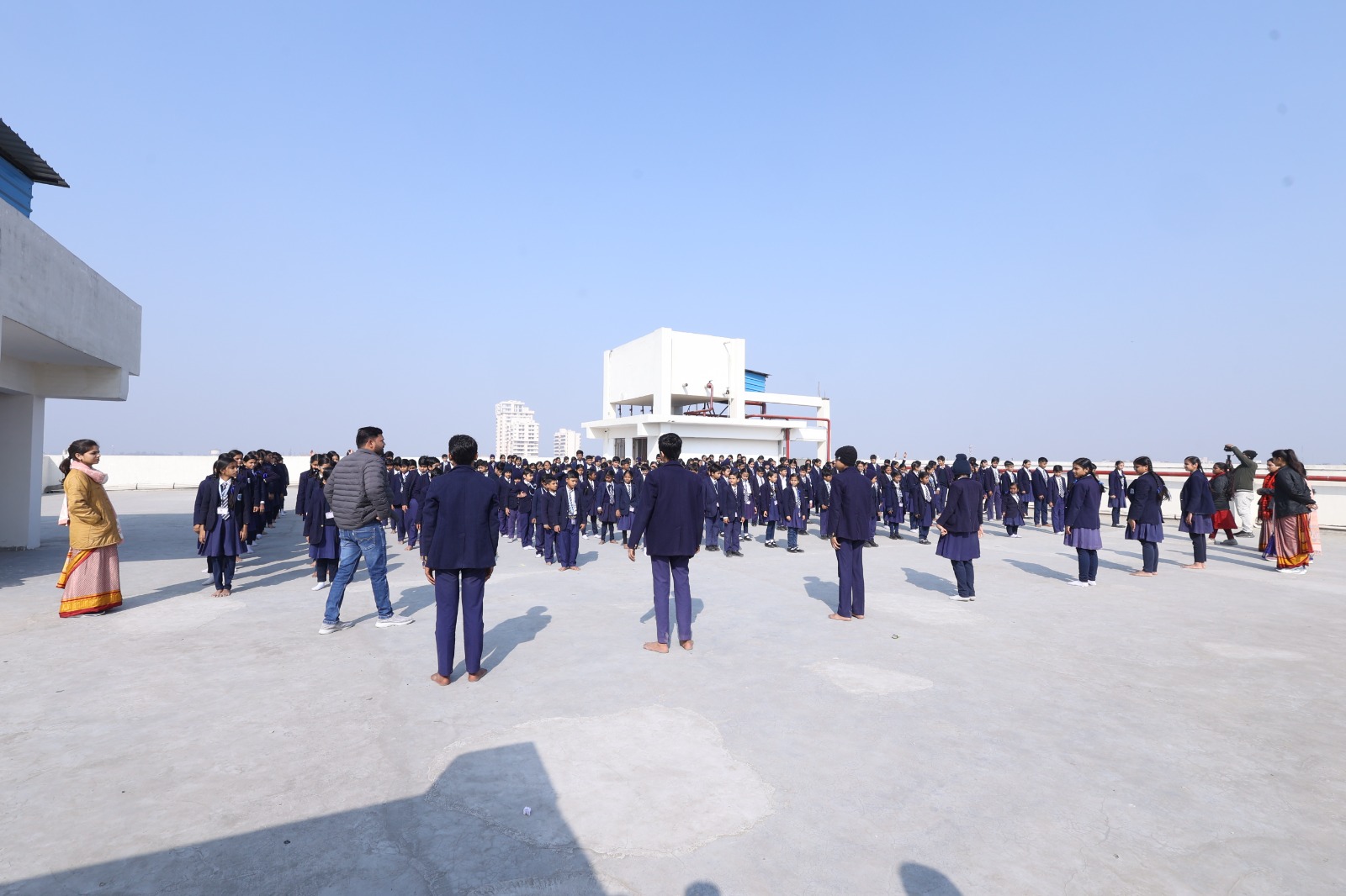Hundreds of students standing in neat formation at the morning rooftop assembly