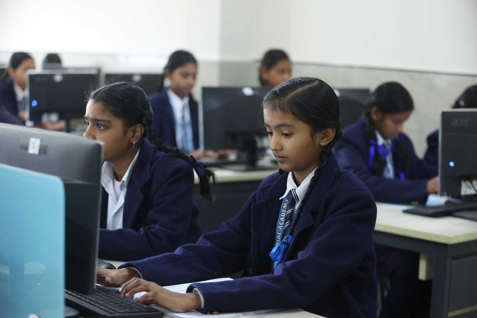 Two girls focused on coursework at their computer terminals