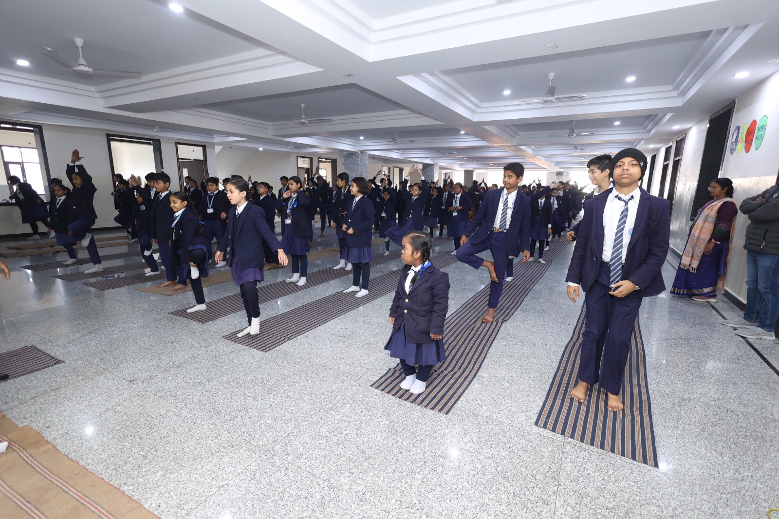 Indoor PT drill with students performing a balanced leg raise