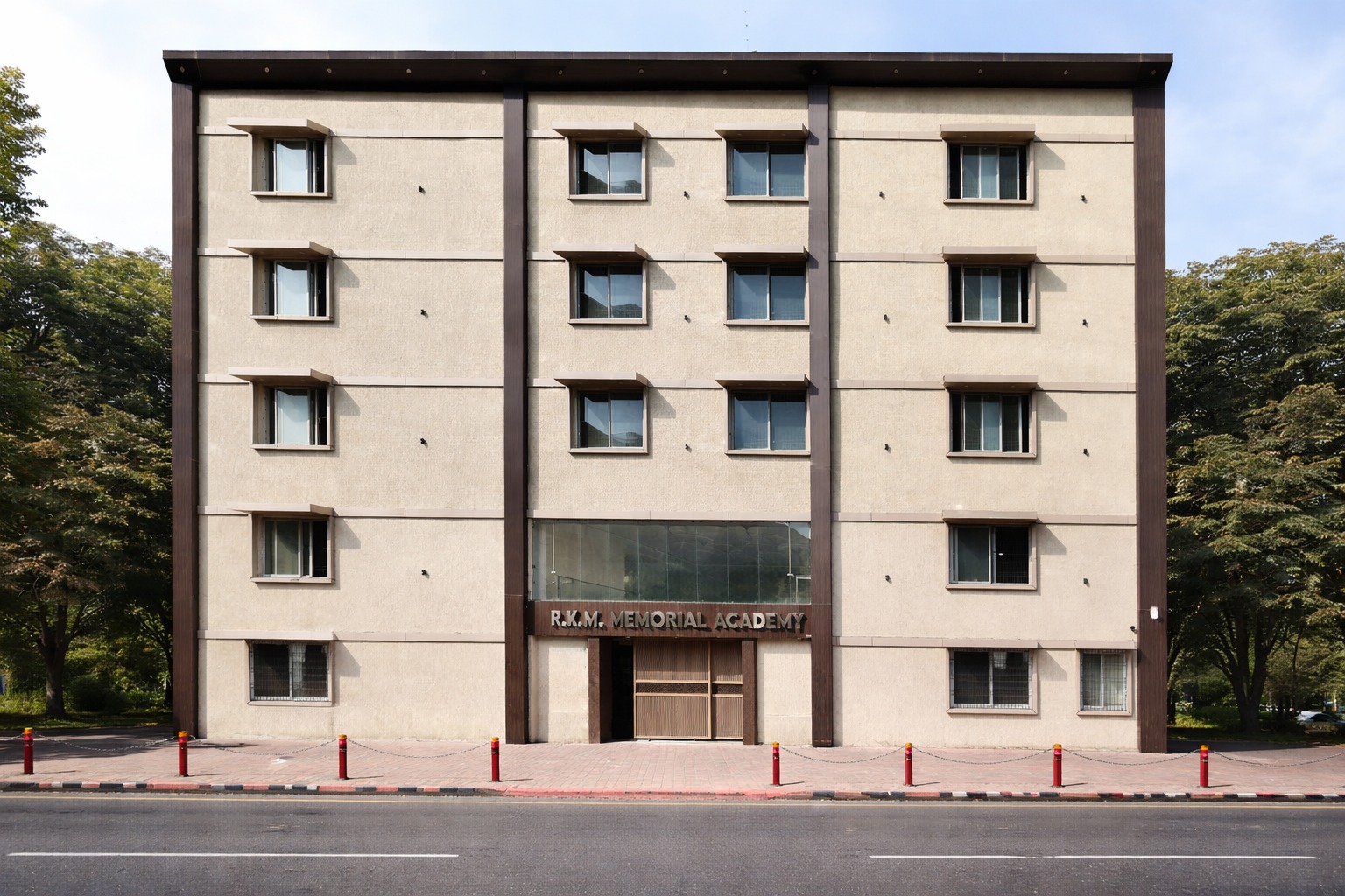 The R.K.M. Memorial Academy building — a five-storey beige facade with the school name above the main entrance